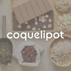 Logo blanc de Coquelipot avec en fond une table recouvert de produits épiciers (chocolats, féculents, épices, herbes, riz)